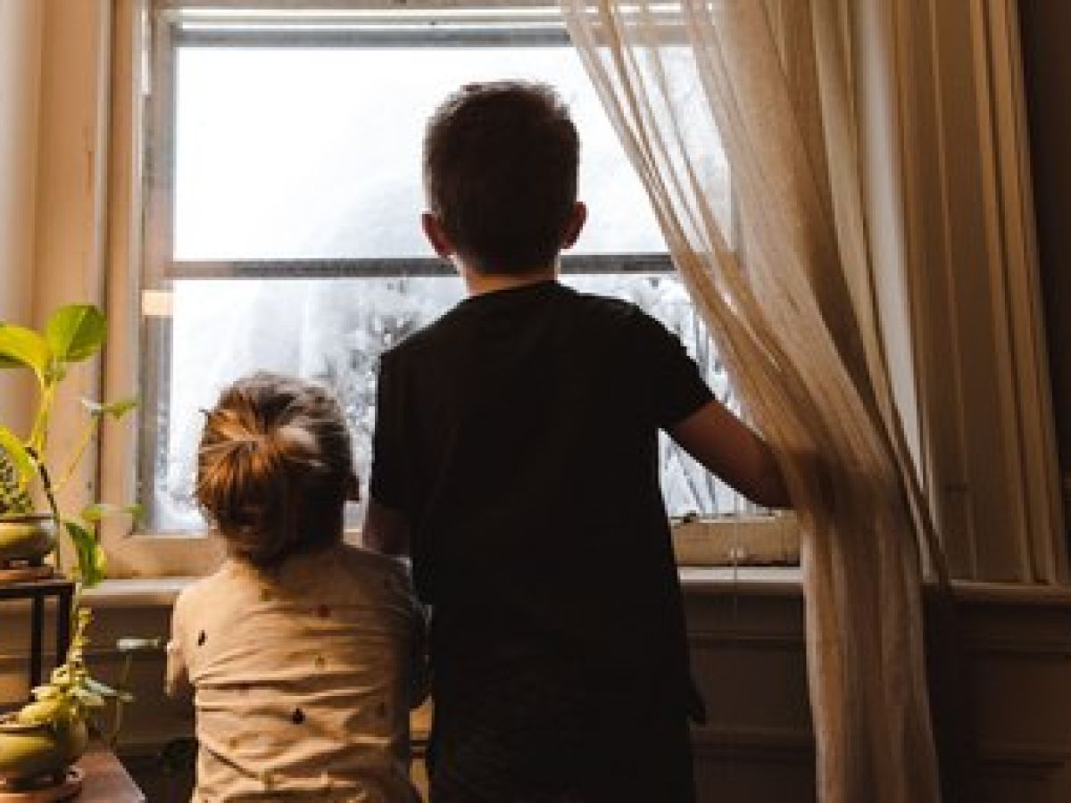 photo taken from behind of kids looking out window.