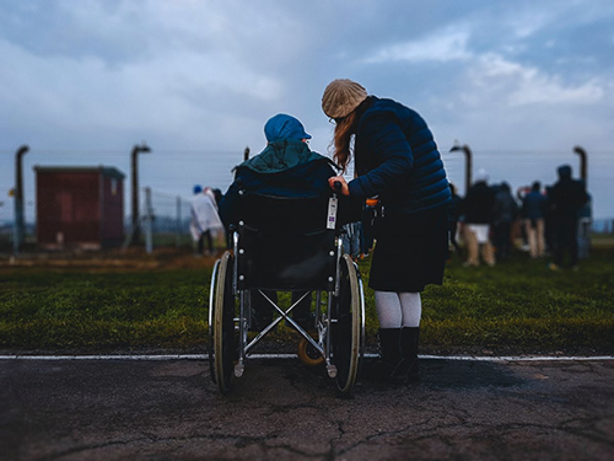 photo of person in wheelchair with someone standing next to them.