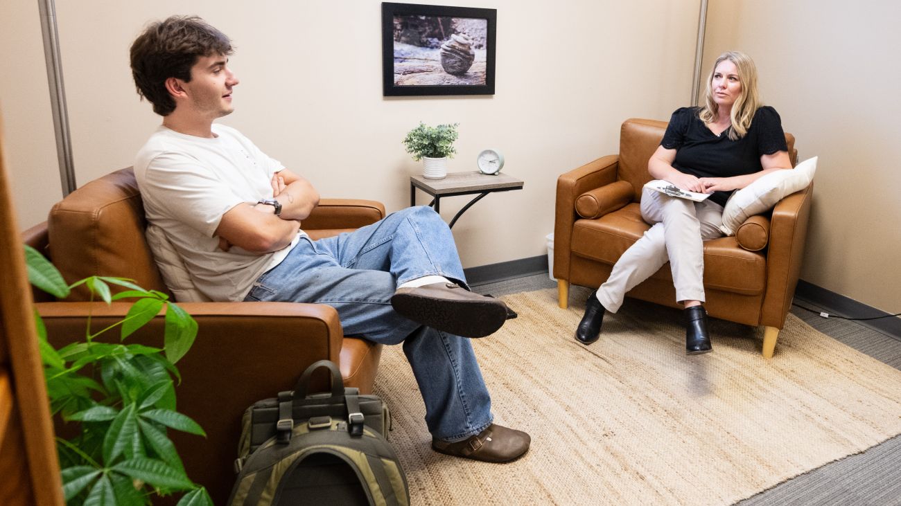 A male student sits across from a counselor during an individual counseling session at Curry Health Center.