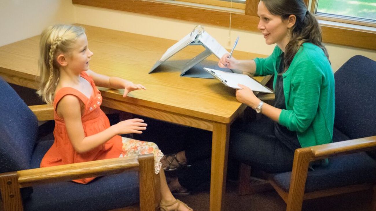 school psychologist working with a child administering a psychological assessment in a school setting.