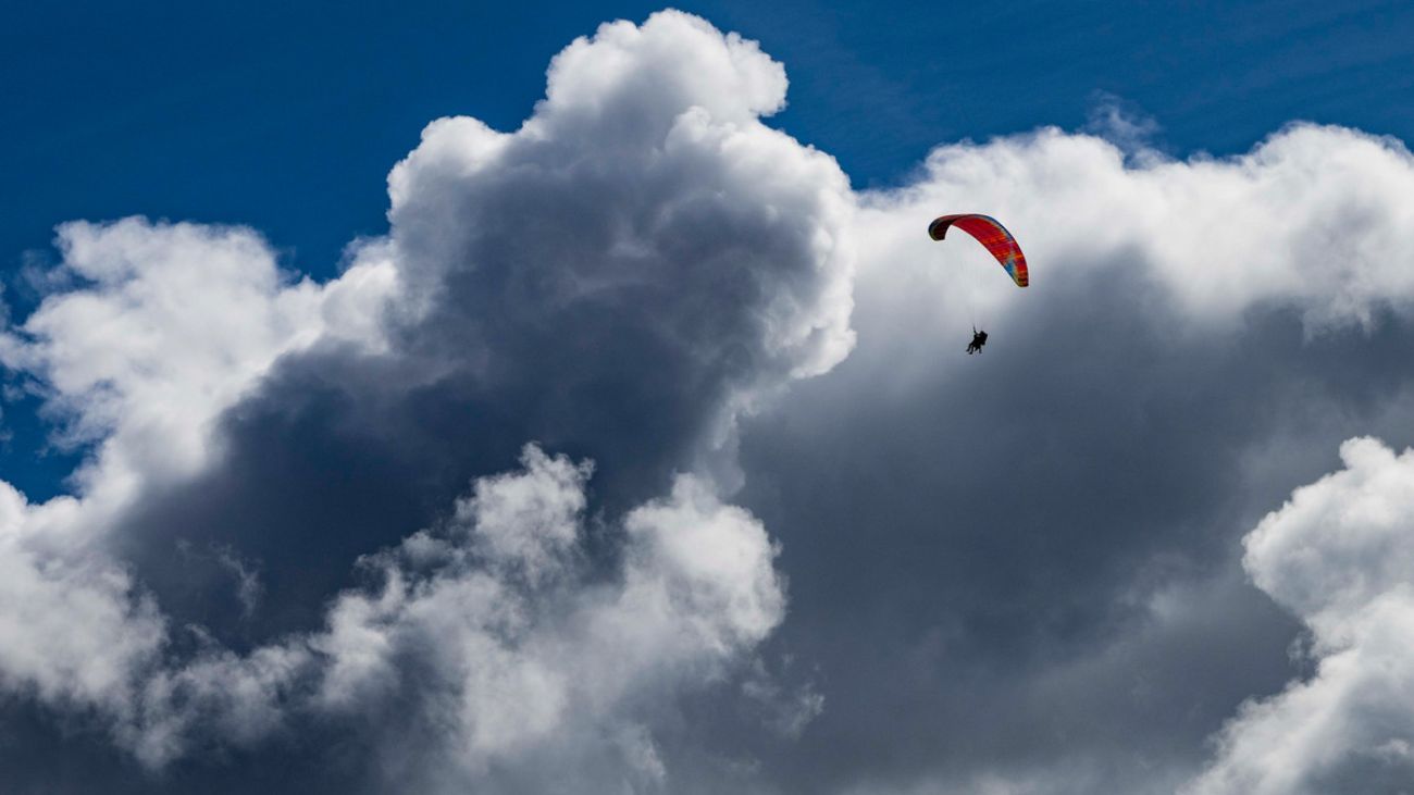 image of a single paraglider floating through a big white cloud