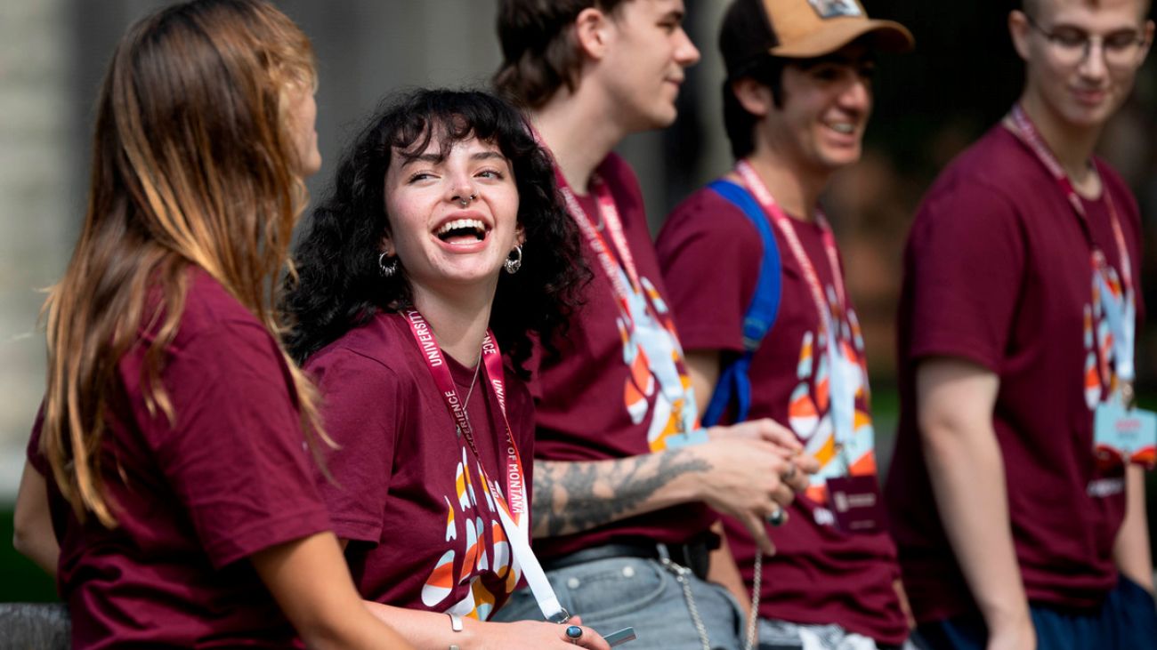 Students in maroon shirts laugh and cheer together