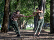 two dancers in a duet outside among trees