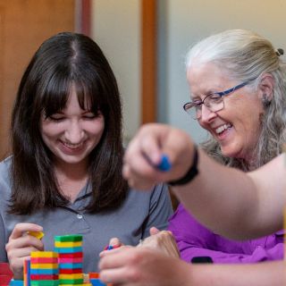 A student and faculty member using math manipulatives
