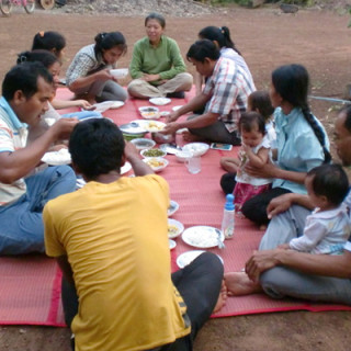 outdoor picnic with 10 people sitting in a circle on a blanket