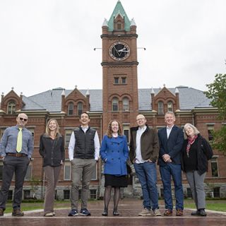 faculty members Tobin Miller Shearer, Kelly Dixon, Scott Arcenas, Gillian Glaes, Kyle Volk, Ashby Kinch and Kathryn Shanley standing in front of main hall