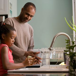 Man and young girl washing hands