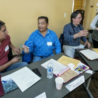 several people sit at a table in discussion