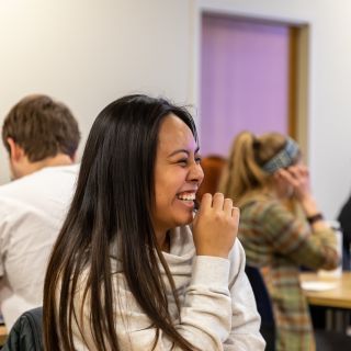 College of Education student laughs while chatting with classmates.