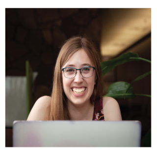 Girl smiling up from laptop