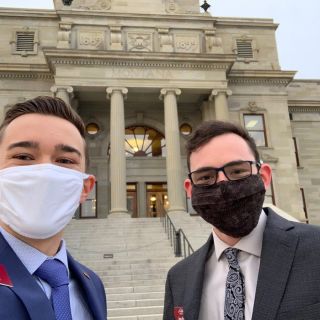 Two UM students wearing masks stand outside the Montana capital building
