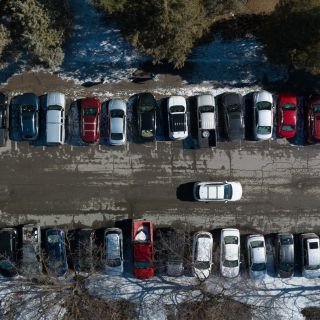 aerial photo of parking lot in winter, only showing to aisles of parking