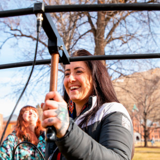 A woman smiles and holds a piece of equipment