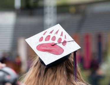 Mortar cap on graduating student with griz paw on top