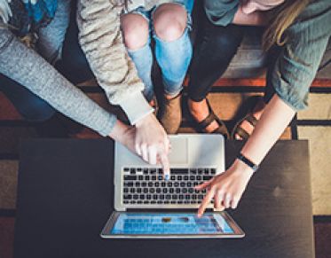 3 students working together on a laptop