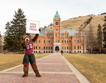 Monte the mascot holding a sign in front of Main Hall that reads: "YOU GOT THIS."