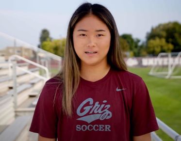 UM student Camellia Xu speaks at the camera while standing in the bleachers of South Campus Stadium