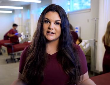 UM student Jesse Storment speaks at the camera while standing in the Missoula College Nursing Lab.
