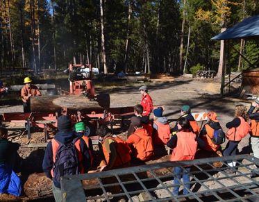 Students watch a demonstration of the sawmill at Lubrecht with professor of wood science Ed Burke