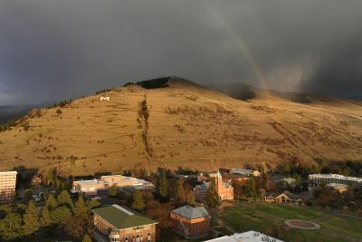 Mount Sentinel basked in sunlight after a storm with a rainbow overhead