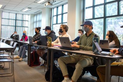 Masked UM College of Business students sit in a UM classroom