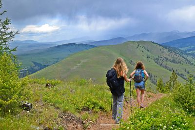 Two women hike down a trail on a mountain near Missoula.