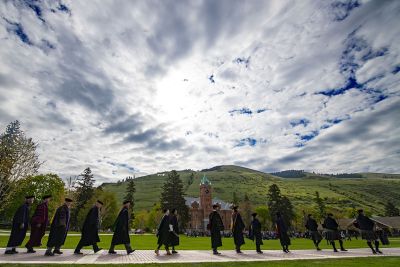 Administrators in graduation attire line up on the UM Oval.