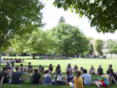 UM students sitting in a circle on the Oval
