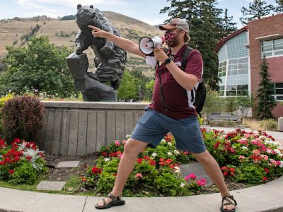 Bridger talks into a megaphone and points