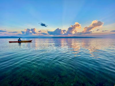 Colorful sunset on flathead lake with a canoe on the water. 