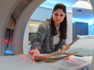 Graduate student placing antler in scanning device