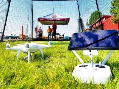 A white drone and operating equipment sit outside on the grass.