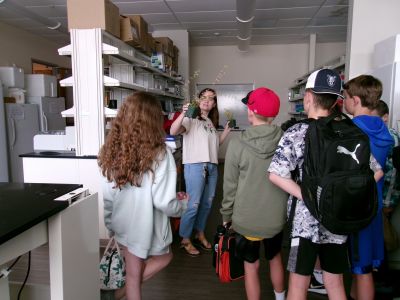 A graduate student shows some students an ecology research lab.