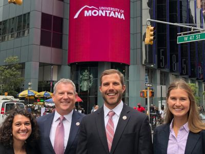 group of people in suits standing in a row outside in a busy city