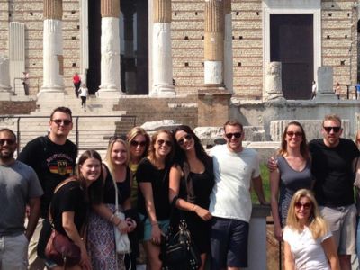 people smiling and posing in a group at a historic site