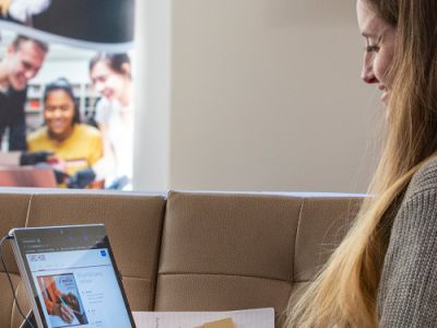 person sitting and looking and working at a laptop