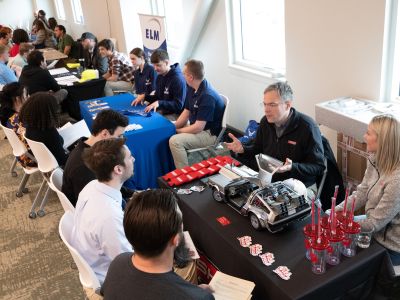 Students sit across tables from potential employers conducting mock interviews at a career day