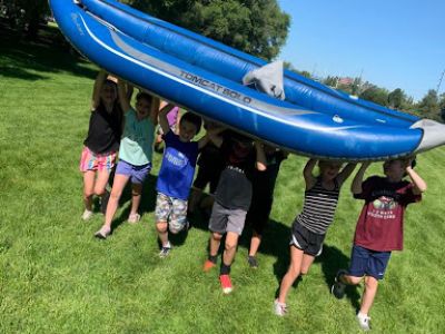 Children carrying an inflatable raft