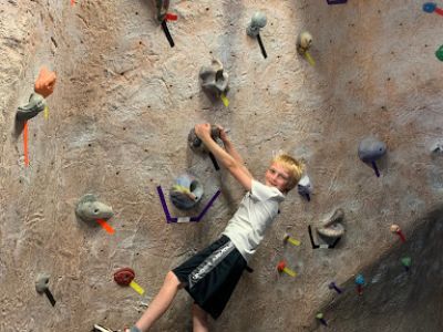 Child climbing on a rock wall in a climbing gym