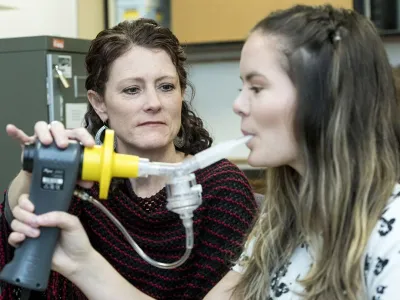 Person holding machine as someone breathes into it