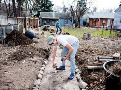 two students doing yardwork at the UM FLAT