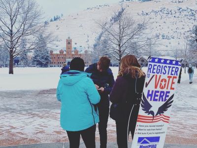 two student volunteers register another student to vote