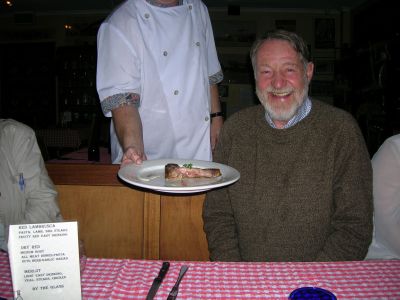 Don smiles while a waiter hands a plate with food.