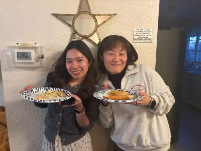 Two women smiling holding plates of food