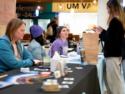 students smile in front of display table