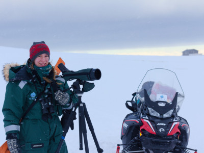 Student stands in the arctic with camera