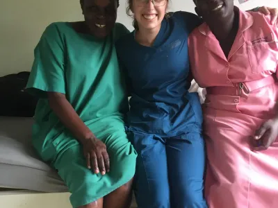 student smiles with colleagues in Uganda