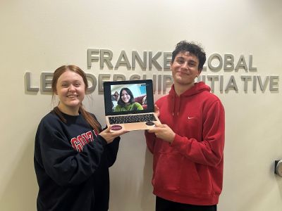 students stand in front of sign