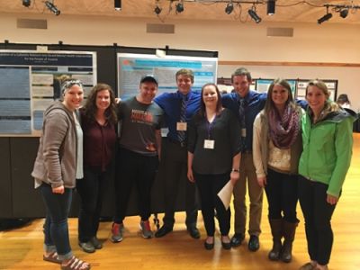 CRESP Lab Members standing in front of a poster at a conference