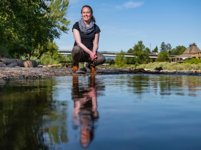 Woman kneeling by Clark Fork River